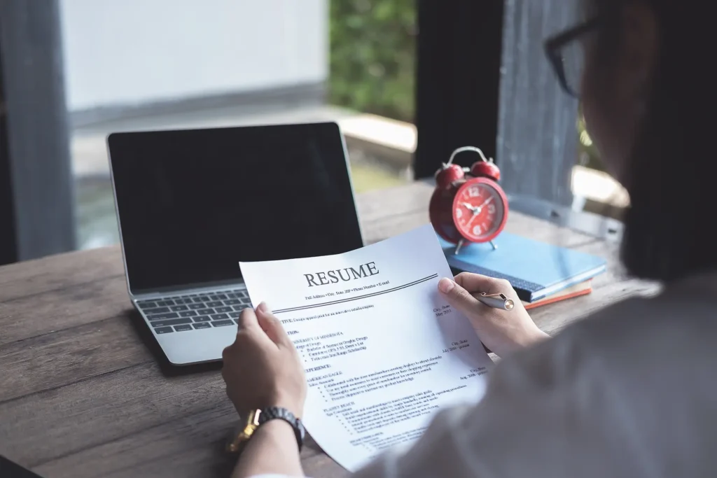 Business man review his resume application on desk, laptop computer, job seeker