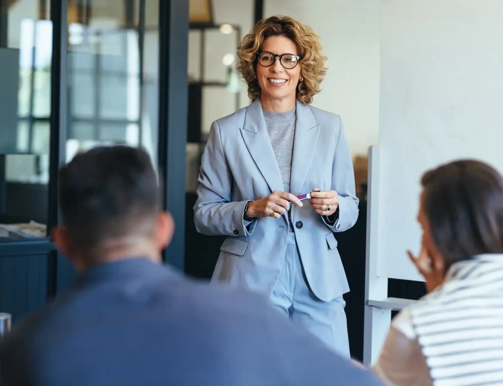 Mature business woman having a discussion with her team. Woman leading a meeting in an office